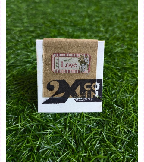 2XCOIN matchbox sitting on grass